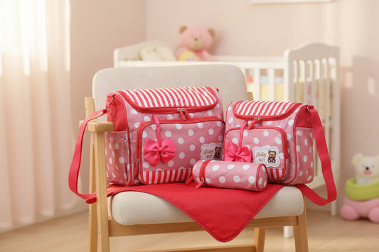 Pink and white striped and polka dot diaper bag set with a teddy bear design on a white background