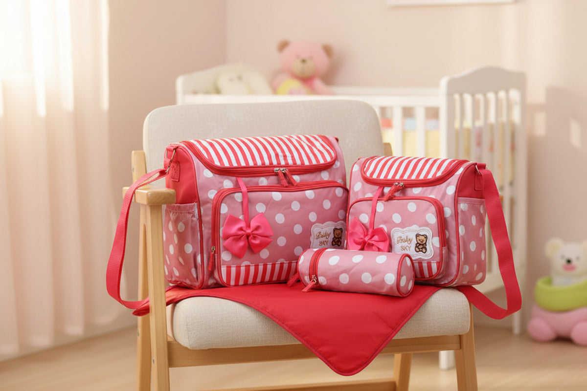 Pink and white striped and polka dot diaper bag set with a teddy bear design on a white background
