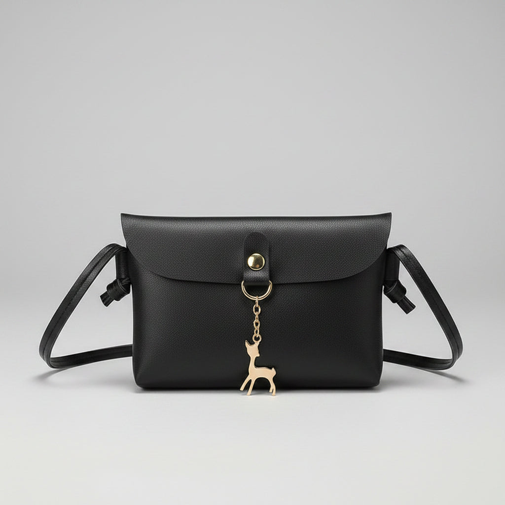 Black handbag held by a hand on a magazine background