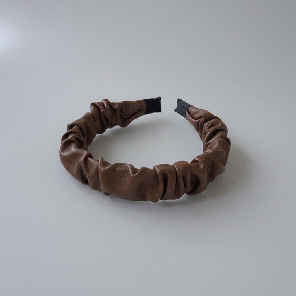 Brown leather headband on a white surface