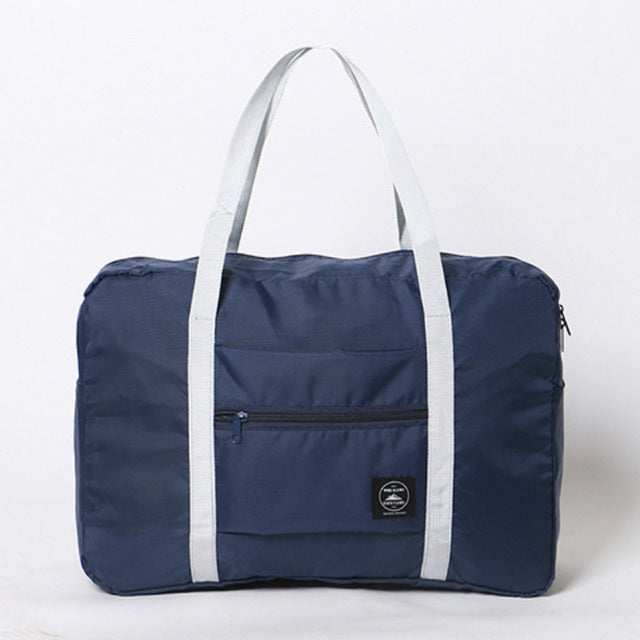 Navy blue duffel bag with white handles on a light gray background
