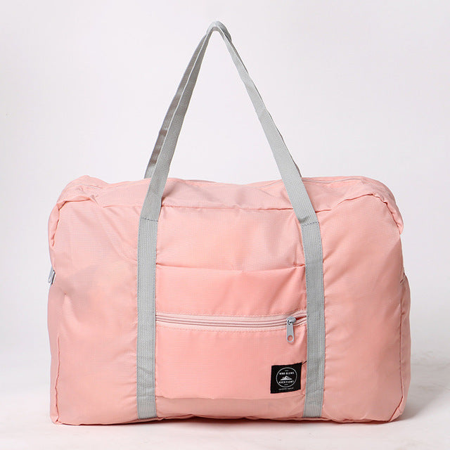 Pink duffel bag with gray straps on a white background