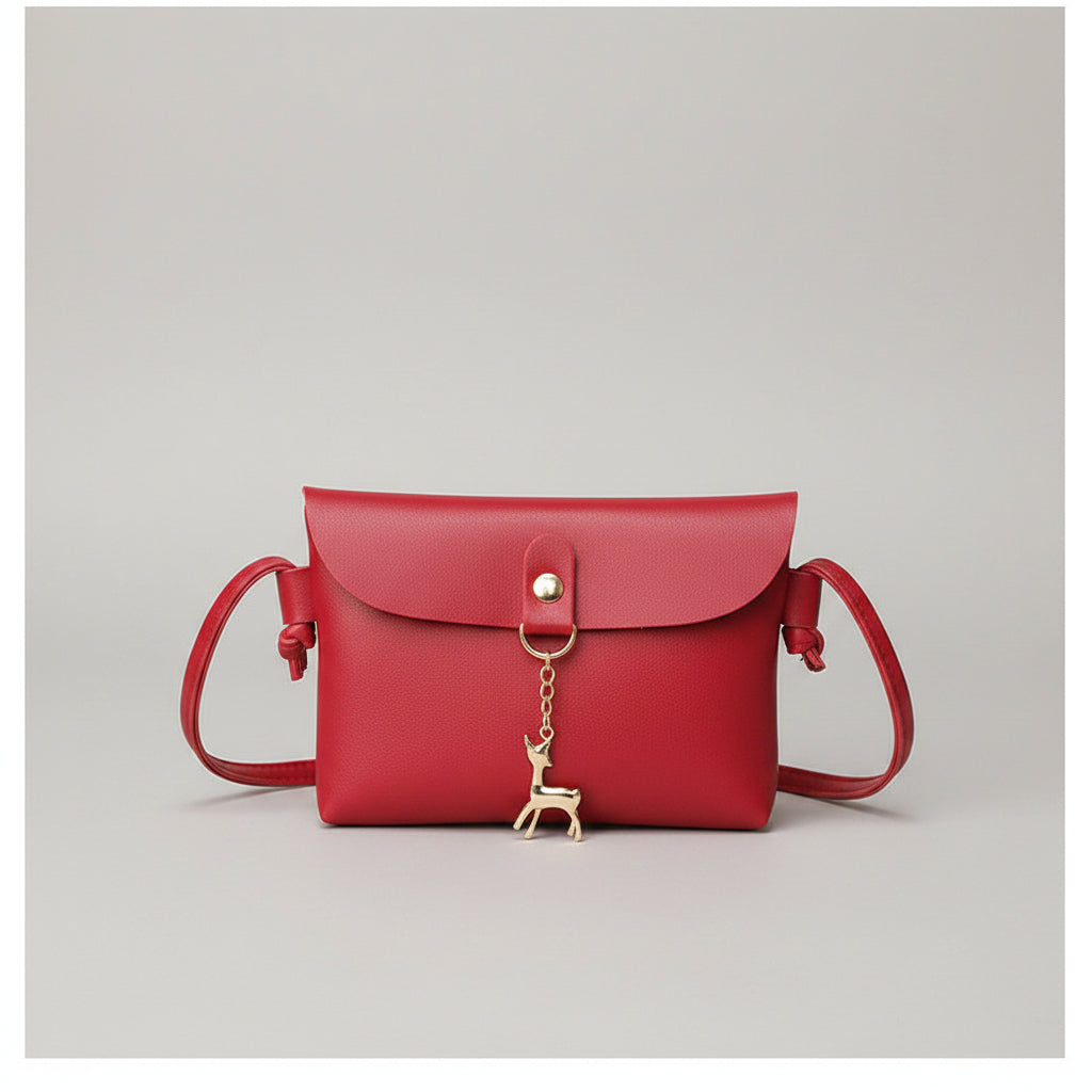 Red handbag held by a person wearing a white jacket with 'AUTUMN' text.